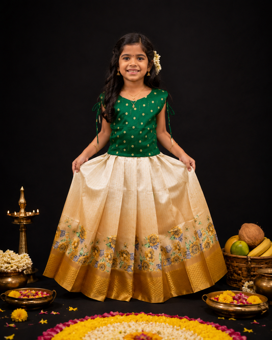 Girl wearing emerald green silk blouse with cream silk Pattupavada skirt featuring multicolour floral border and gold zari hem