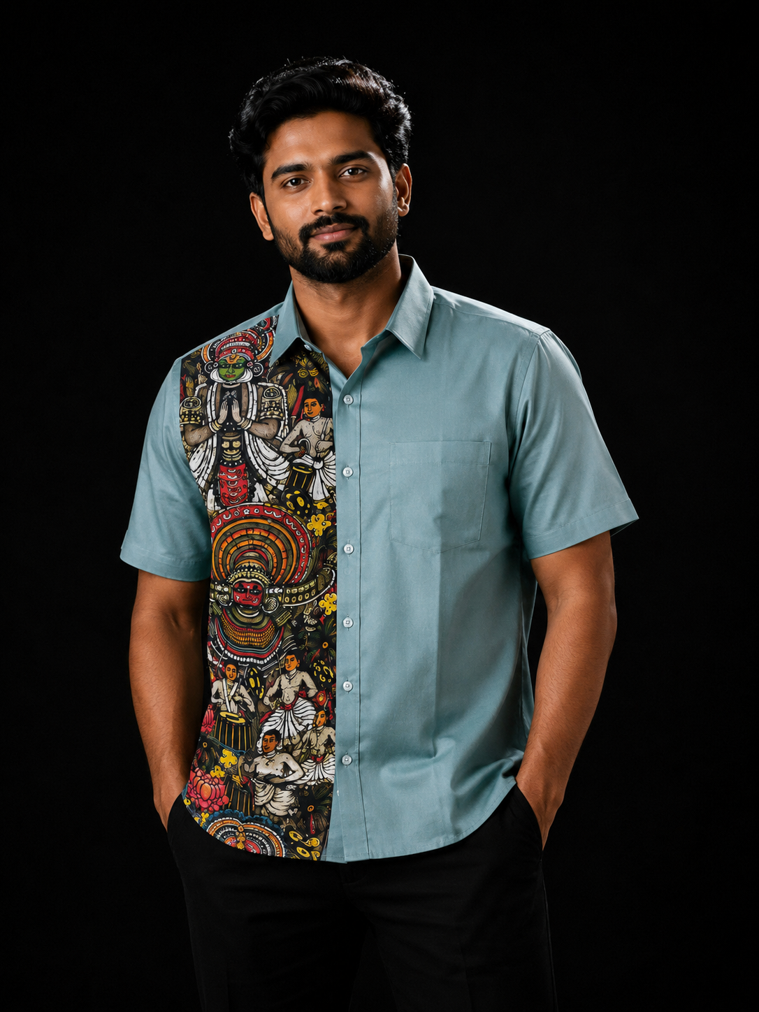 Man wearing a teal short-sleeve shirt with a Kerala art panel on the left featuring Kathakali, Theyyam deities, classical performers and floral motifs on a dark background